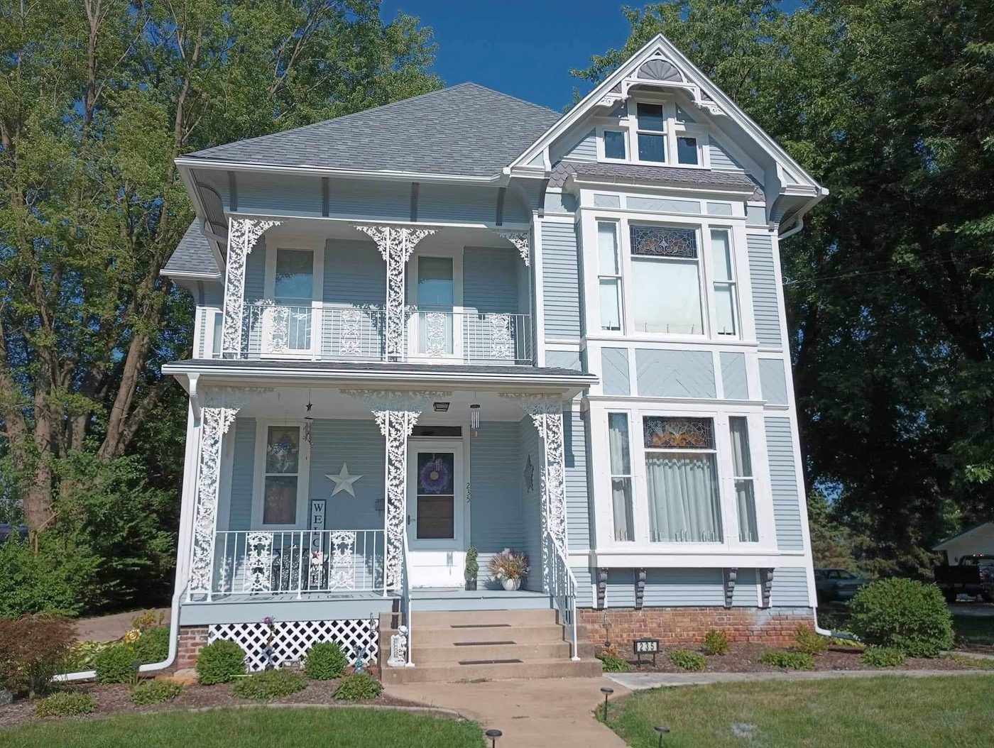Historic Victorian home painted light blue with detailed white trim